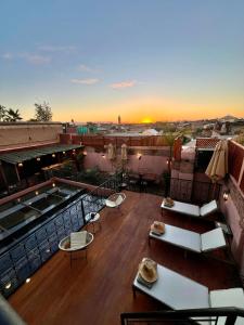 a balcony with tables and chairs on top of a building at Riad Ecila in Marrakech