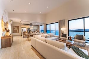 a living room with white furniture and large windows at 3082 - Paradise Cove 3A Manzanillo in Tangolunda