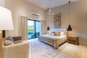 a bedroom with a bed and a chair and a window at 3082 - Paradise Cove 3A Manzanillo in Tangolunda +29 photos
