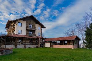 een groot huis met een groen gazon ervoor bij Vâlceaua Zânelor in Stațiunea Climaterică Sâmbăta