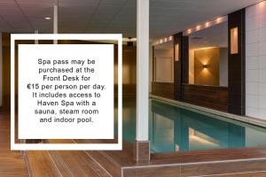 a sign next to a swimming pool in a building at DoubleTree by Hilton Rotterdam Centre in Rotterdam