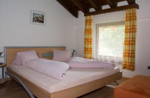 un lit dans une chambre avec une fenêtre dans l'établissement Chasa Val Bella, à Samnaun