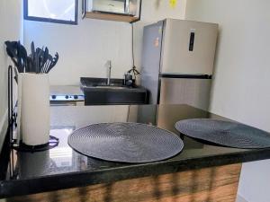 a kitchen with two plates on a counter with a refrigerator at Flat confortavel e aconchegante in Cabo Frio +11 photos