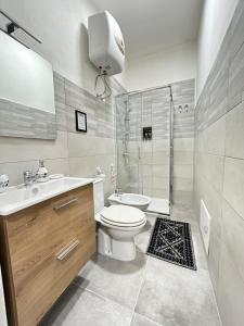 een badkamer met een toilet, een wastafel en een douche bij GrivHouse B&B in Sassari