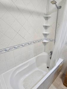 una vasca bianca in un bagno piastrellato bianco di Blife Ampalya private rooms a FAO