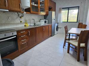 una cucina con armadi in legno, un tavolo e una sala da pranzo di Blife Ampalya private rooms a FAO Altre 7 foto