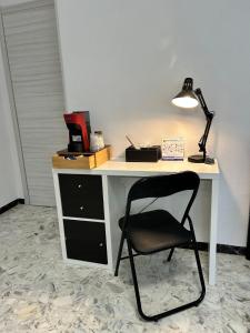 een bureau met een stoel en een lamp erop bij GrivHouse B&B in Sassari