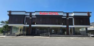 un hôtel avec un panneau rouge dessus dans l'établissement Rubin Hotel, à Navoï