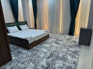 une chambre avec un lit et des haut-parleurs dans l'établissement Rubin Hotel, à Navoï