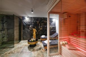 een badkamer met een douche en een muurschildering van bomen bij Hotel Julian Alps in Zgornje Gorje +93 foto's