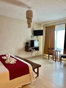 een hotelkamer met een bed en een tv bij Suites Valentina in Puerto Morelos