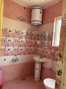 a bathroom with a toilet and a sink at The Atiq Stay in Jāmb +2 photos