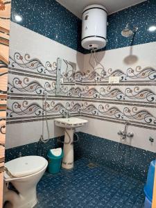 a bathroom with a toilet and a sink at The Atiq Stay in Jāmb
