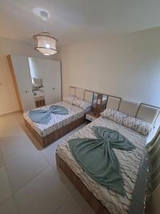 two twin beds in a room with a mirror at مراسي in Sīdī ‘Abd ar Raḩmān