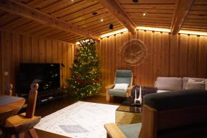 a living room with a christmas tree and a couch at Villa Tolonen a beautiful log villa by the Ivalo River in Ivalo