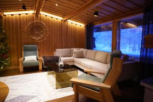 a living room with a couch and a christmas tree at Villa Tolonen a beautiful log villa by the Ivalo River in Ivalo