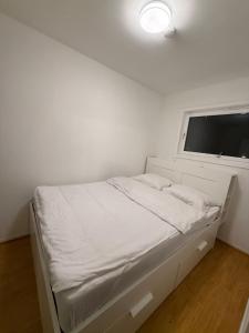 a bed in a white room with a window at Modern Oslo Studio Near Aker Brygge in Oslo
