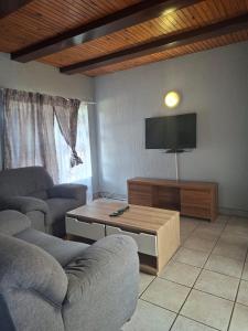 un salon avec deux canapés et une télévision à écran plat dans l'établissement Number 8, à Maseru