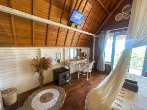 a living room with wooden floors and a ceiling at Hideout Sunset in Nusa Penida