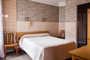 a bedroom with a bed and two chairs and a table at Hôtel de la Comète in Paris