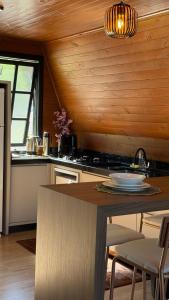 een keuken met een tafel en een aanrechtblad bij Cabana das Oliveiras -2 in Piratuba