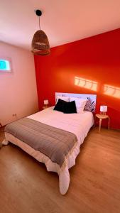 a bedroom with a large bed with a red wall at Chez Patricia et Georges in Carry-le-Rouet