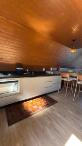 een keuken met een aanrecht, een tafel en stoelen bij Cabana das Oliveiras -2 in Piratuba