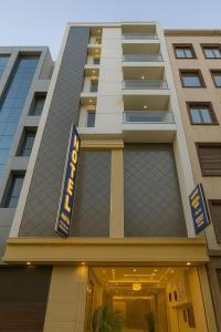 een gebouw met een hotelbord ervoor bij Hotel Emerald Suites & Banquet By Aura in Noida