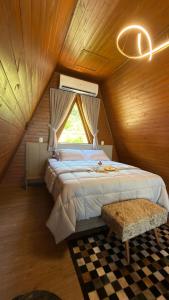 een slaapkamer met een groot bed op zolder bij Cabana das Oliveiras -2 in Piratuba