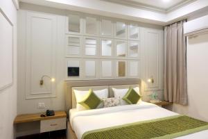 een slaapkamer met een bed en een muur met spiegels bij Hotel Emerald Suites & Banquet By Aura in Noida