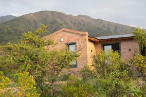 een bakstenen huis met bergen op de achtergrond bij Tintitacos in Los Hornillos