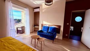 a living room with a blue chair and a table at Chez Patricia et Georges in Carry-le-Rouet