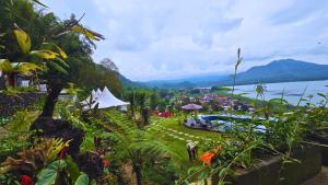 een tuin met uitzicht op een stad en het water bij Adelisca Glamping, Cafe and Villa in Kubupenlokan