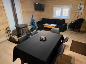 a living room with a table and a christmas tree at Domek drewniany Szafran in Witów