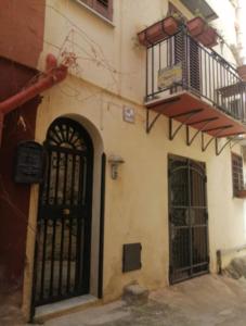 a building with a black door and a balcony at Tomicla in Monreale