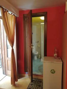 a bathroom with a toilet and a red wall at Tomicla in Monreale