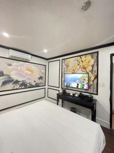 een slaapkamer met een bed en een flatscreen-tv bij Diamond Hotel in Long Biên