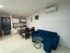 a living room with a blue chair and a kitchen at MINGO House BA ĐÌNH in Hanoi