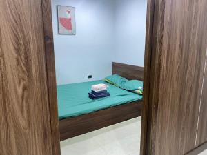 a small bedroom with a bed with green sheets at MINGO House BA ĐÌNH in Hanoi