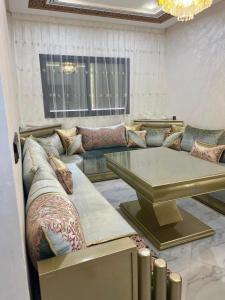 een woonkamer met een bank en een tafel bij Shahd in Meknès