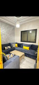 een woonkamer met een blauwe bank en een tafel bij Shahd in Meknès