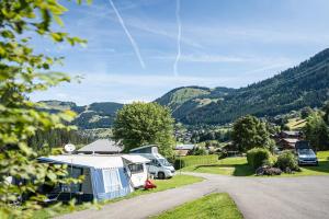 a campsite with a rv and cars parked on a road at Camping L'Oustalet in Châtel