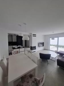 ein weißes Wohnzimmer mit einem weißen Tisch und Stühlen in der Unterkunft Villa Elmiso Sarajevo in Sarajevo