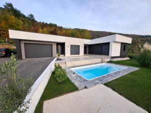 a house with a swimming pool in the yard at Villa Elmiso Sarajevo in Sarajevo
