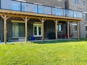 a house with a porch with a bench on a lawn at Whitby Hideout - 3BR, 5BD, 3WR, Pool Table, Sauna in Whitby