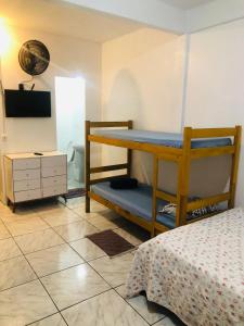 een slaapkamer met een stapelbed en een televisie bij Pensionato Marlu I in Balneário Camboriú