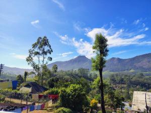 un albero in primo piano con montagne sullo sfondo di Munnar Valley View Annex a Munnar