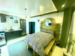 een slaapkamer met een bed en een keuken met een wastafel bij Tu7 Apartments in Accra