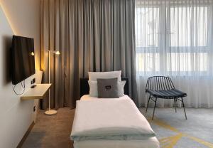 een hotelkamer met een bed en een televisie bij Holiday Inn - the niu, Coin Frankfurt Ostend by IHG in Frankfurt am Main +61 foto's