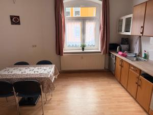 een keuken met een tafel en stoelen en een raam bij Ferienwohnung Goldener Drache in Jugelsburg